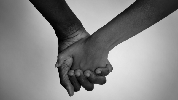 2 people holding hands black and white image